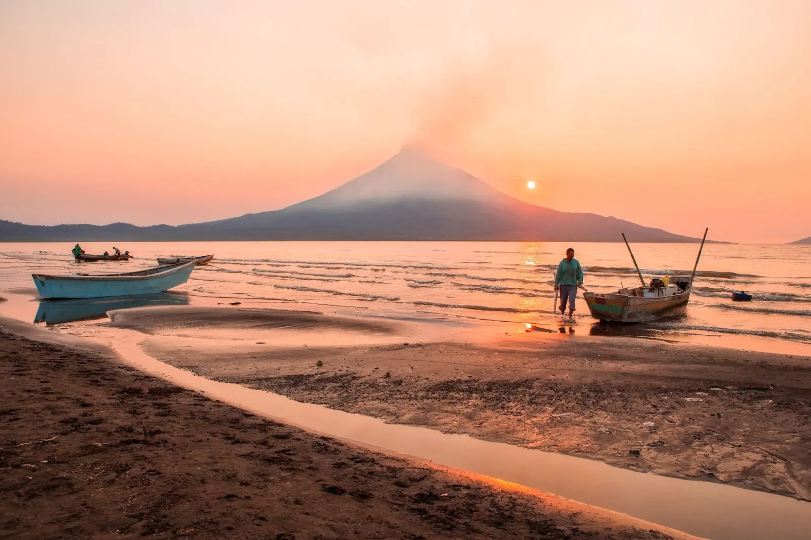 Fisherment preparing to go fishing in Lake Managua, Nicaragua, with Momotombo volcano in the background.