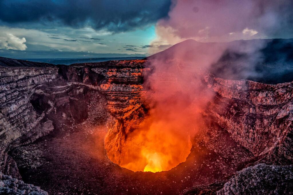 Volcano crater eruption with flowing lava and smoke. The Masaya Volcano near Managua, Nicaragua main crater after sunset.