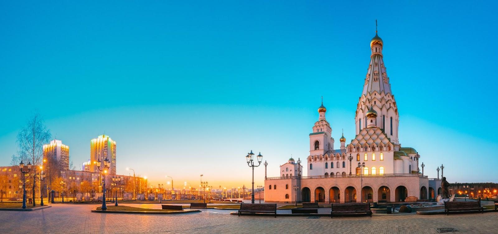 Minsk, Belarus. Panoramic View Of All Saints Church In Sunset Time. Minsk Memorial Church In Memory Of The Victims, Which Served As Our National Salvation. Evening Lighting.