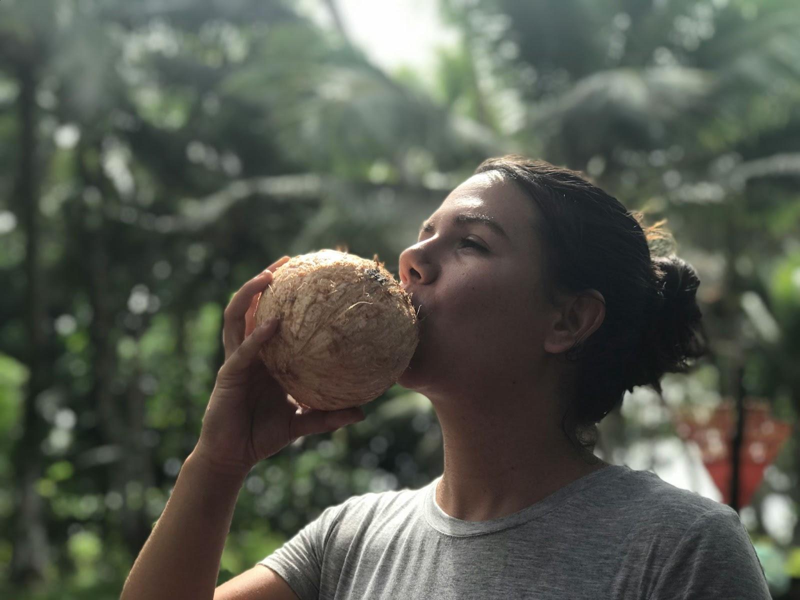 woman drinking coconut juice straight from the coconut Vanuatu