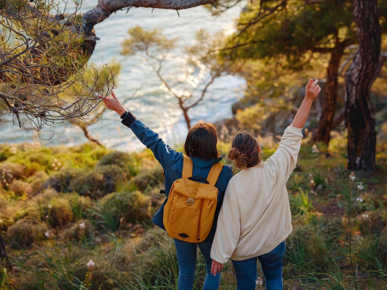 trip to Turkey, two women enjoy sunset over Fethiye city. Unity, mental health, eco travel. Hiking in mountains and hugging, travelling, good moments, digital detox