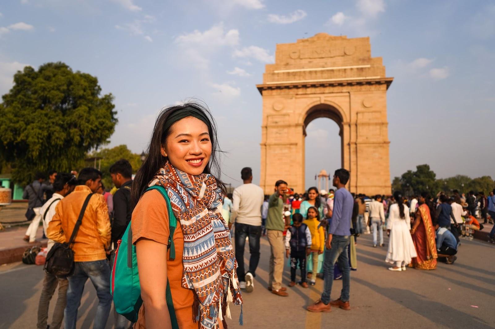 young woman (Chinese ethnic) tourist in front of India Gate monument in the capital of India