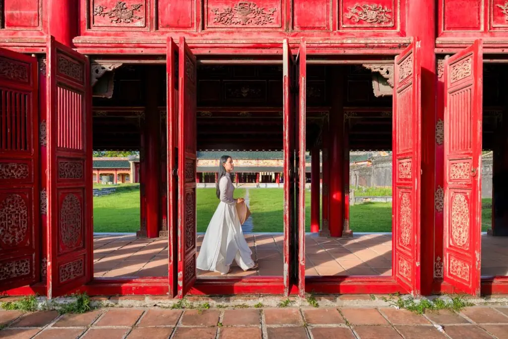 HUE, VIETNAM - AUG 23, 2022: TOURISTS IN TO THE IMPERIAL CITY, WITH THE PURPLE FORBIDDEN CITY WITHIN THE CITADEL IN HUE, VIETNAM. IMPERIAL ROYAL PALACE OF NGUYEN DYNASTY IN HUE. HUE IS A POPULAR