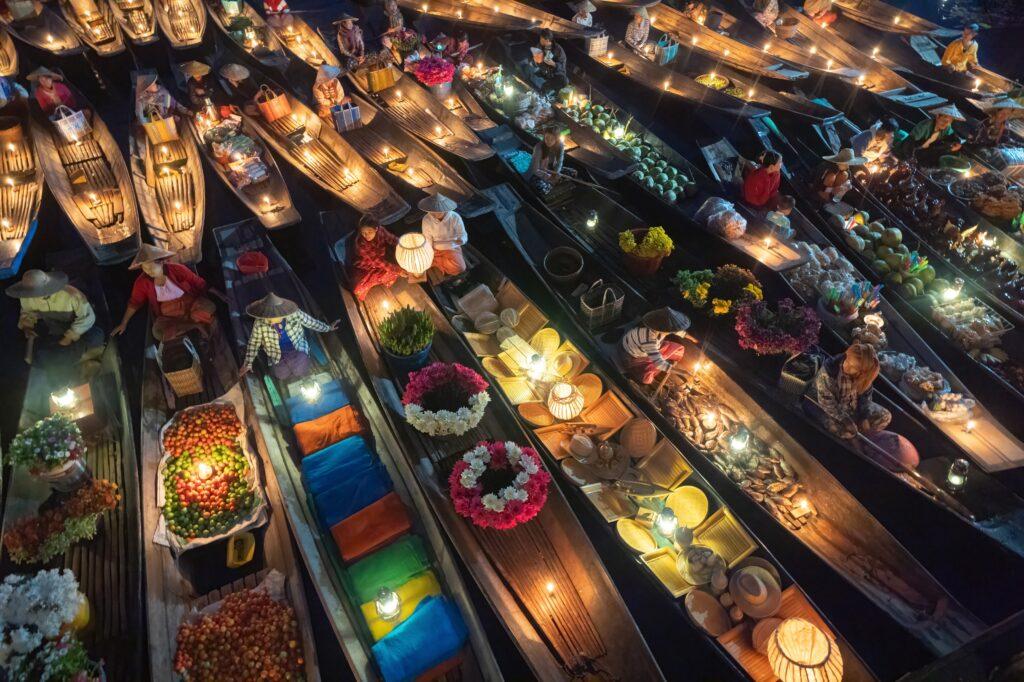 Damnoen Saduak Floating Market or Amphawa. Local people sell fruits, traditional food on boats in canal, Ratchaburi District, Thailand. Famous Asian tourist attraction destination. Festival in Asia.