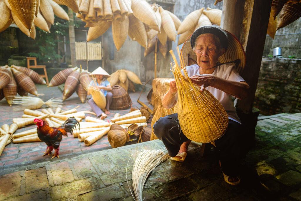 Vietnamese fishermen are doing basketry for fishing equipment at morning in Thu Sy Village, Vietnam.