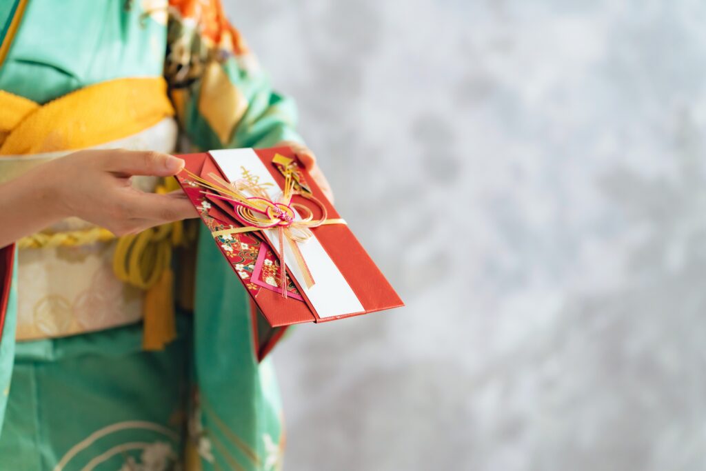 woman in kimono holding a Japanese gift envelope. Wedding blessings. Japanese translation:"happy".