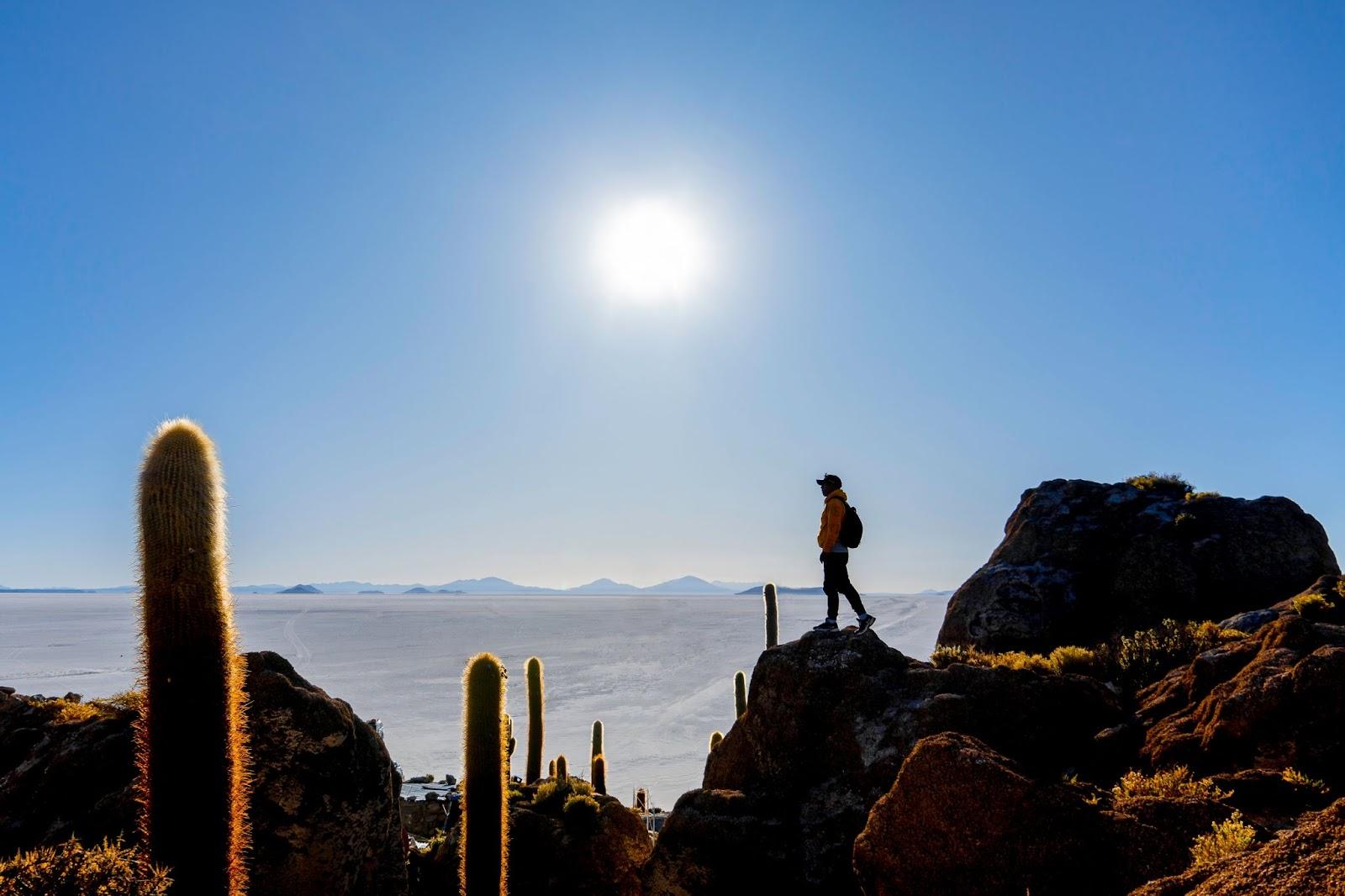 Tourist watching sunrise over the majestic Salar de Uyuni