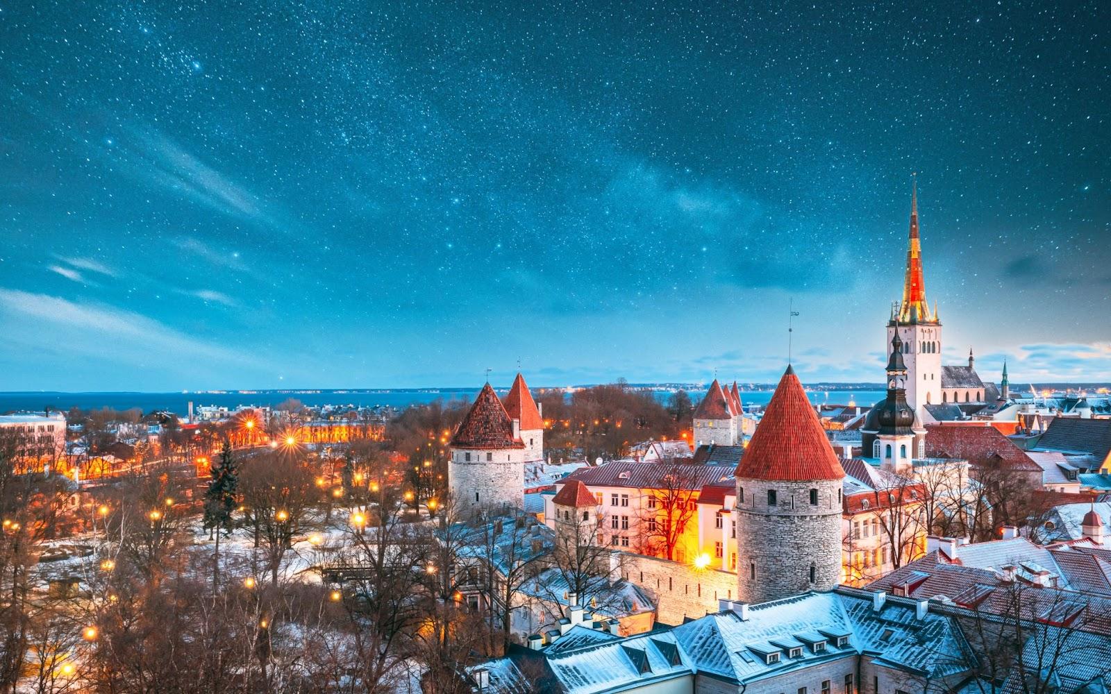 Tallinn, Estonia. Night Starry Sky Above Old Castle Walls Architecture. Cityscape Skyline In Old Town. Winter Evening Night. Famous Landmark. Popular Destination Scenic. UNESCO Heritage. Altered Sky