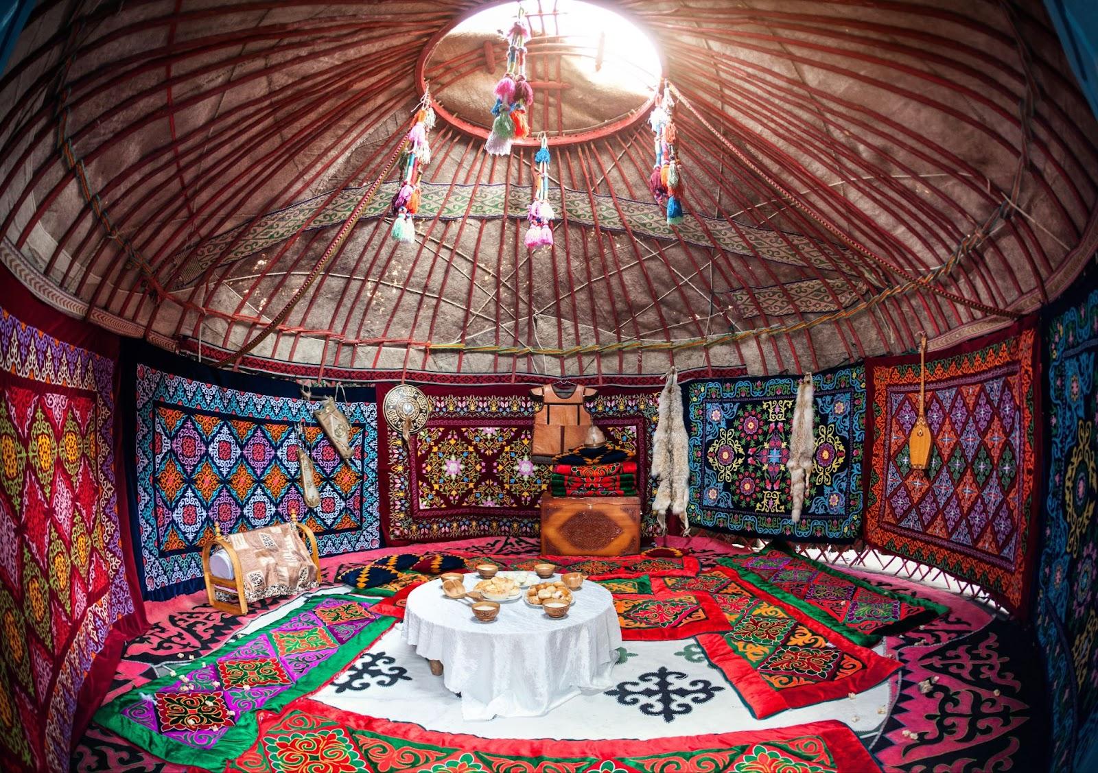 Ethnic nomadic house yurt interior with table of national food at Nauryz celebration