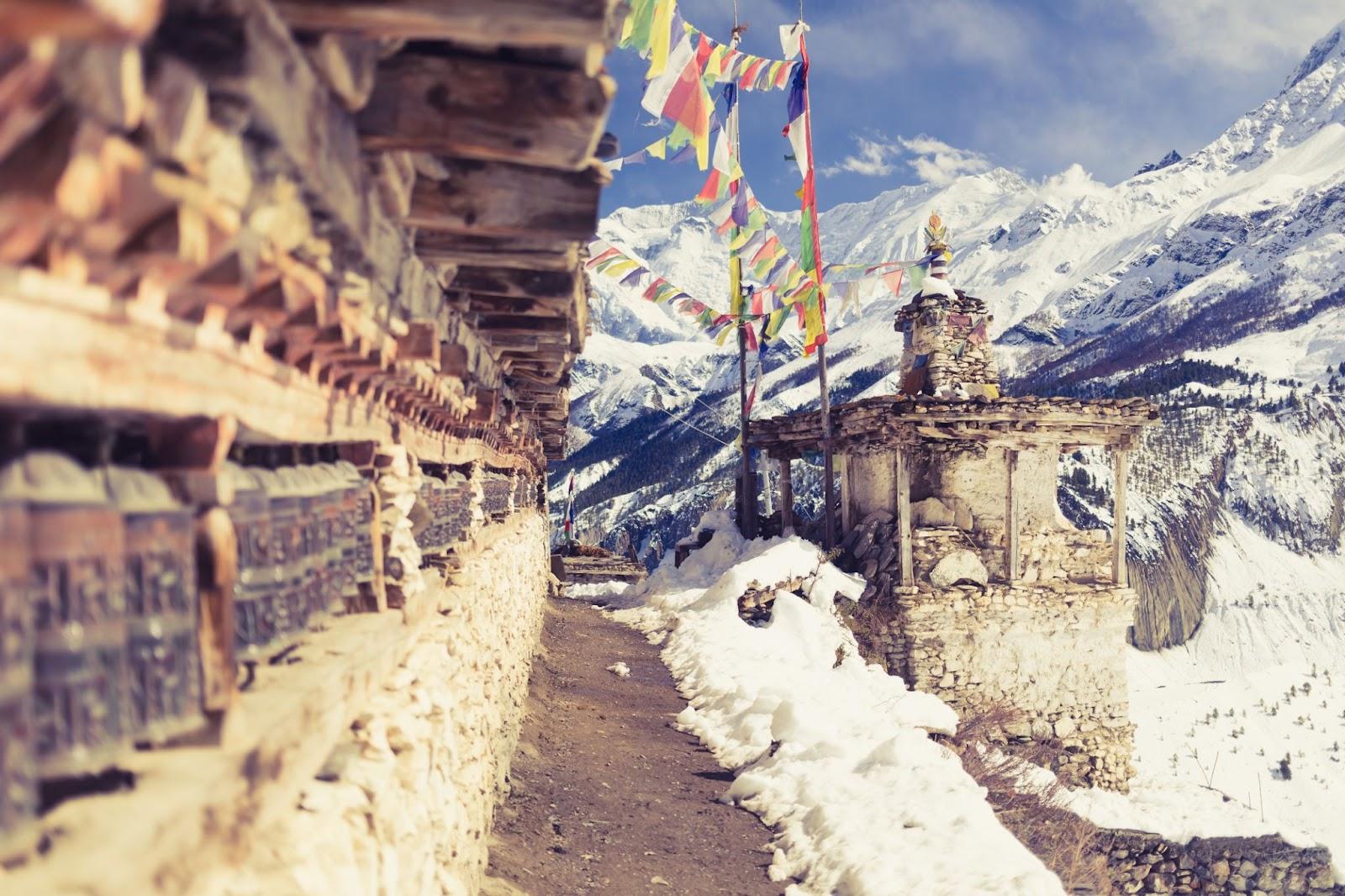 Prayer wheels in high Himalaya Mountains, Nepal village. Focus on the stupa and prayers flags. Annapurna Two range region in Nepal, located at Annapurna Circuit Trekking Hiking Trail