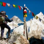 View of Everest with hiker or tourist and buddhist prayer flags from Kala Patthar and blue sky, way to Everest Base Camp, Nepal Himalayas mountains